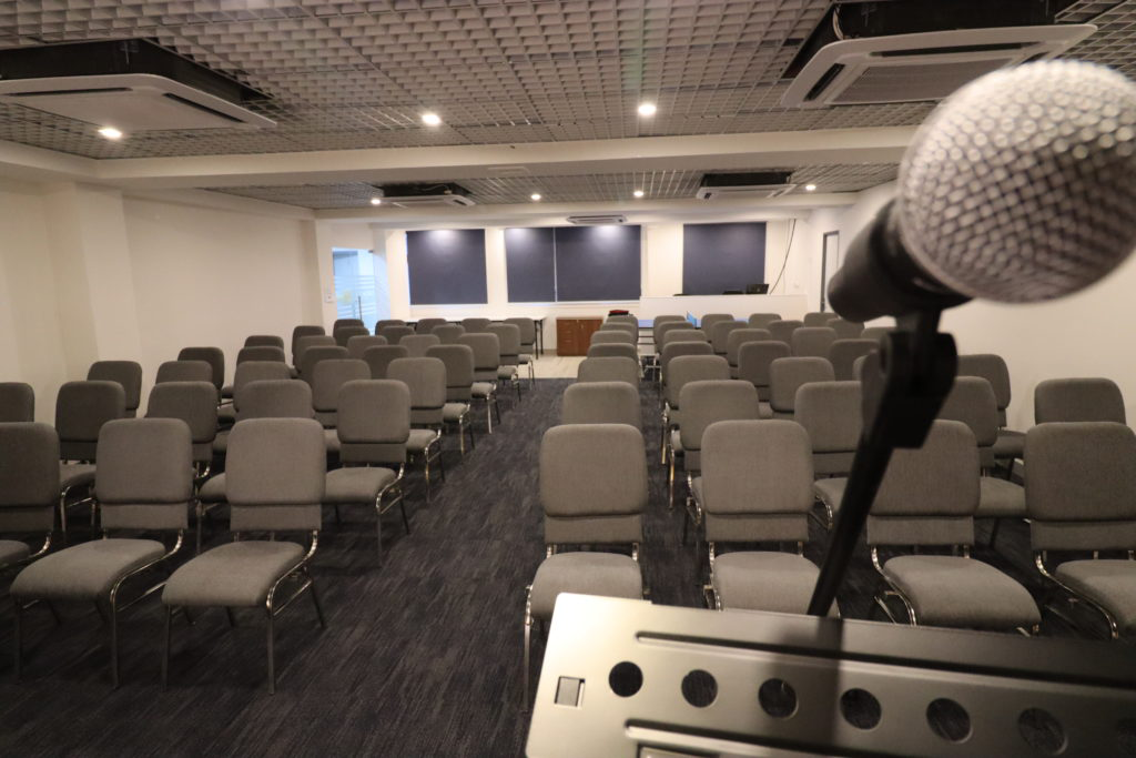 Speakers point to the audience in a conference hall