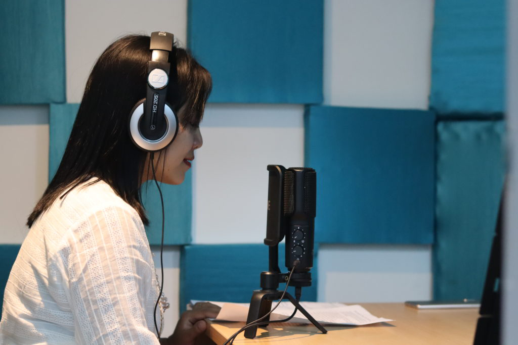 A women recording her audio with respective equipment