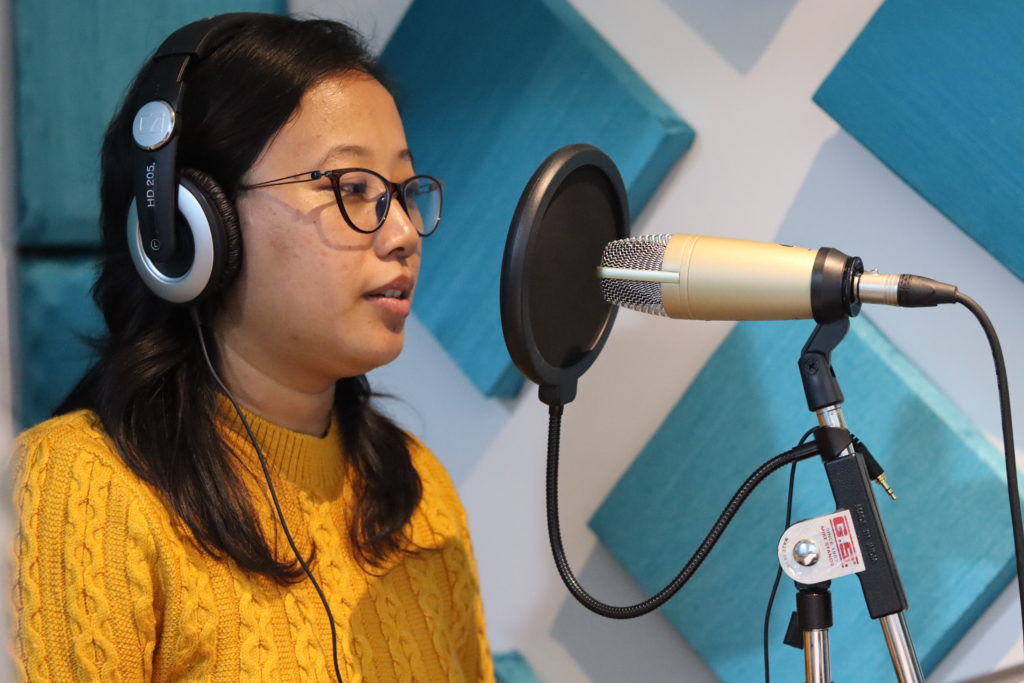 A woman recording with audio equipment